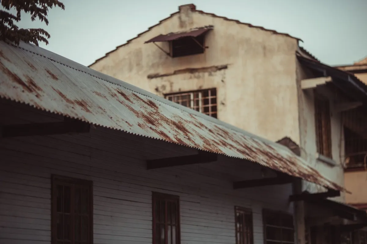 Weathered exposed-fastener metal roof on an outbuilding near Shreveport, LA